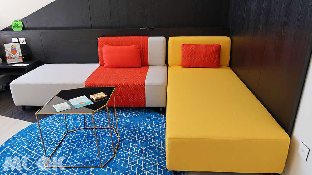 沙發床配色鮮明，與房間單純的白色系呈現對比效果。